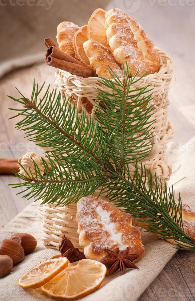 Weidenweihnachtsstrumpf gefüllt mit Keksen, Zimtstangen, kandierter Zitrone und Sternanis foto