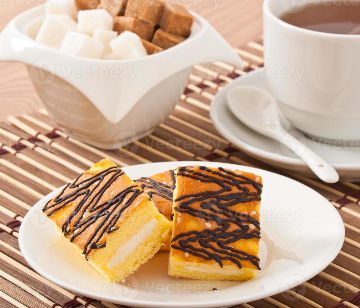 Stück Biskuitkuchen mit Tee und Zucker foto