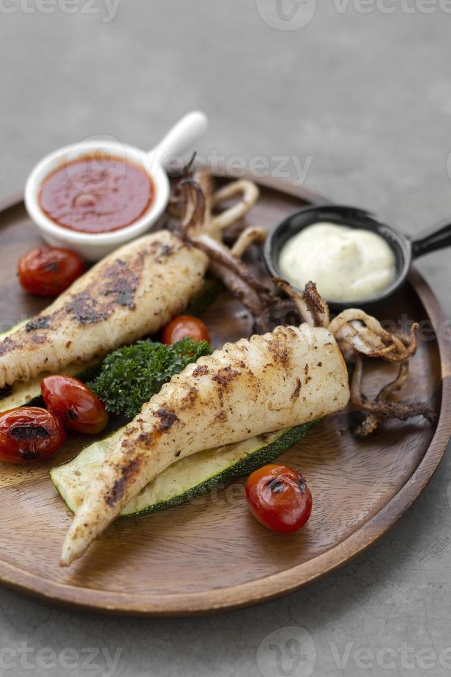 Gegrillter ganzer Tintenfisch mit Aioli und würziger Sauce im spanischen Restaurant foto