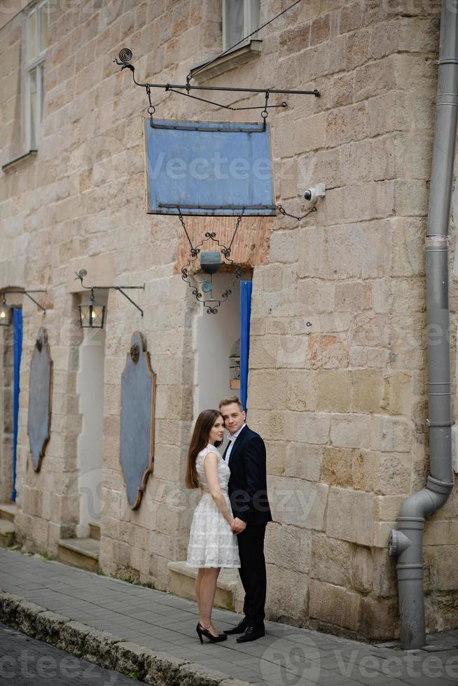 Ein lächelndes Paar genießt Drinks an einem Stehtisch im Freien in der Stadt. der mann sitzt am tisch und schaut auf ein digitales tablet und die frau steht neben ihm. foto