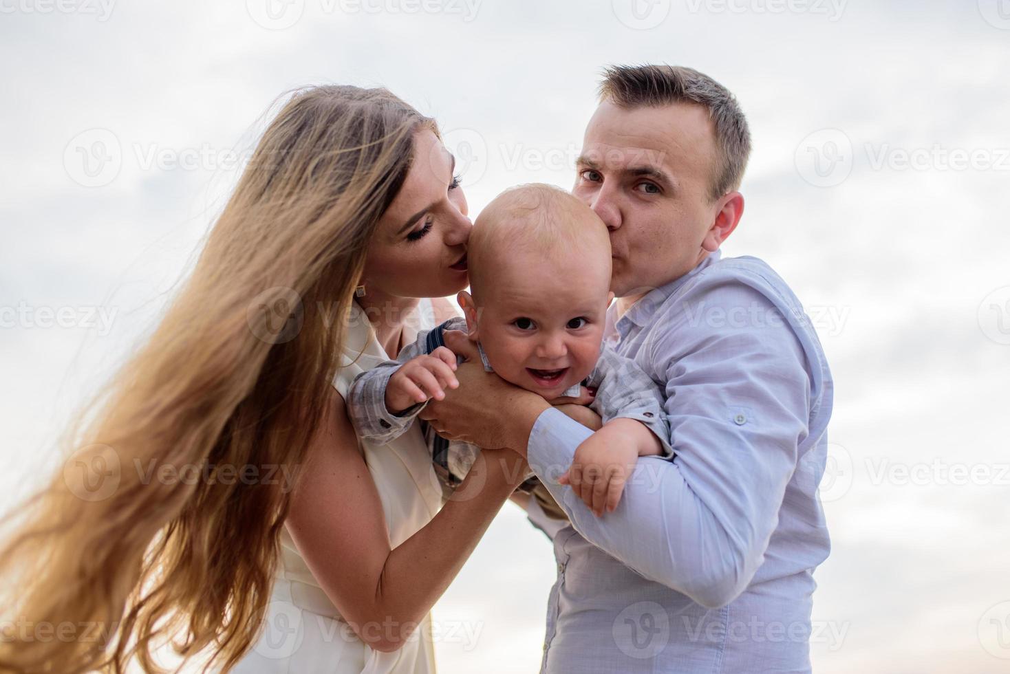 vater und mutter führen ihren einjährigen sohn an der hand. foto