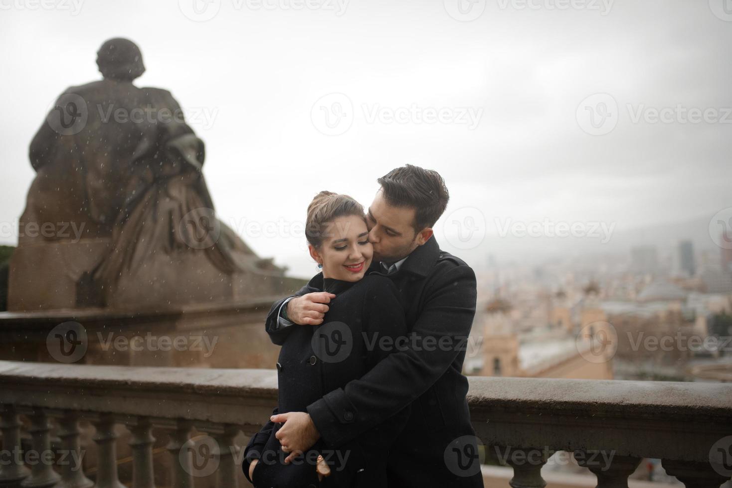 junges schönes liebevolles hispanisches paar geht während des regens unter einem regenschirm spazieren. foto