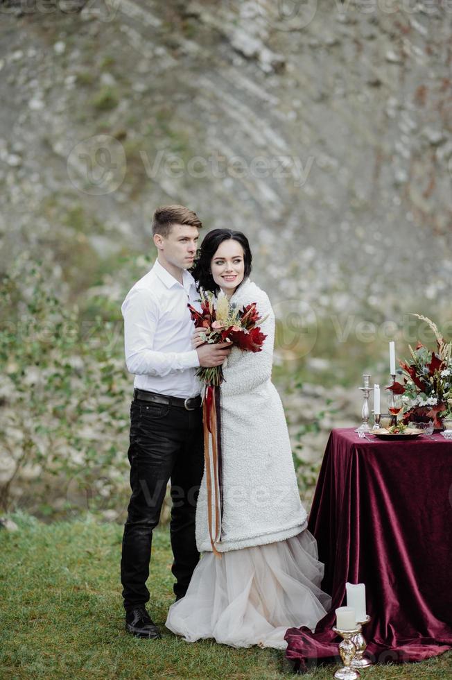 die Braut und der Bräutigam. Hochzeitszeremonie auf dem Hintergrund der Berge foto