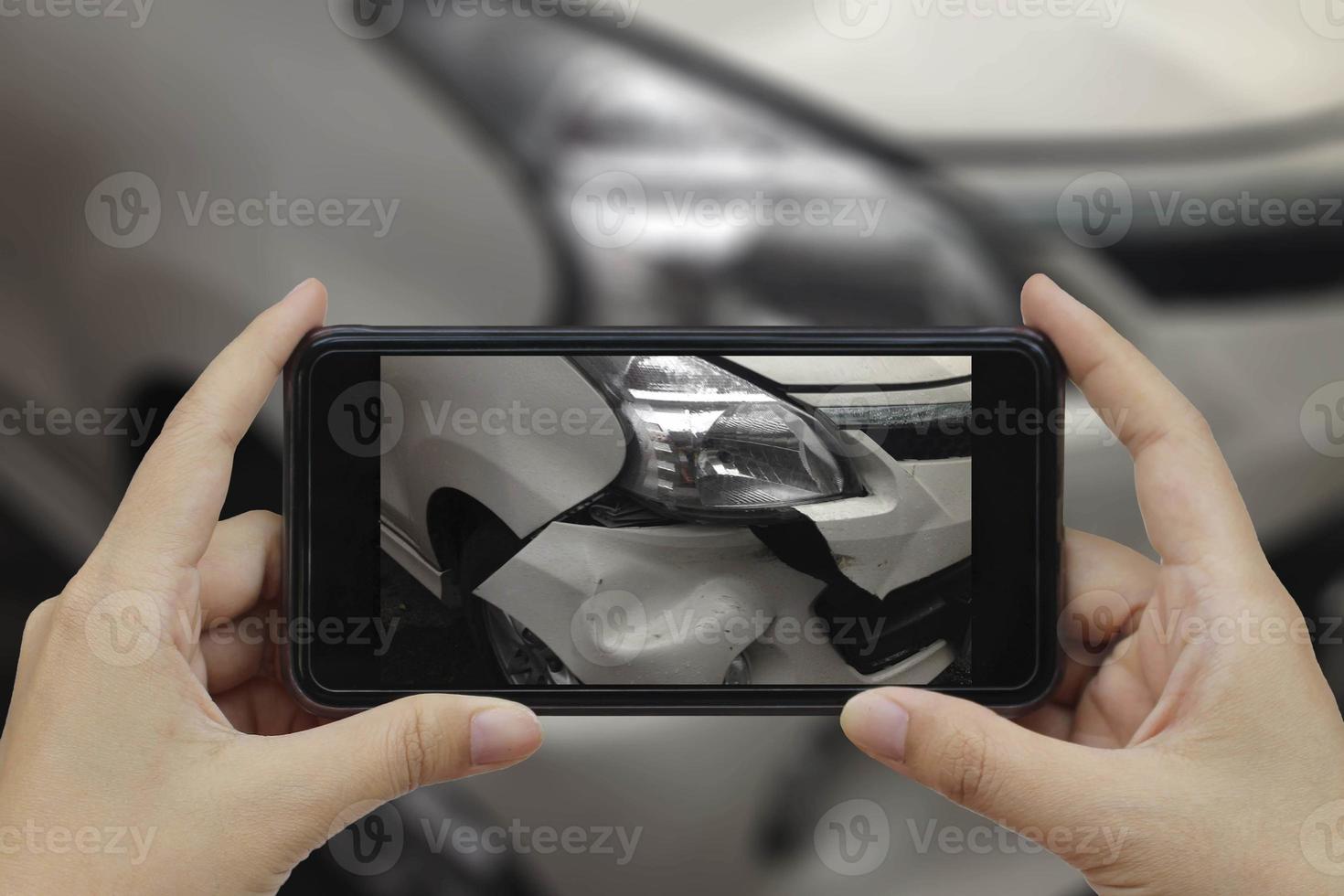 Hand, die ein Smartphone hält, machen Sie ein Foto am Ort eines Autounfalls, eines Autounfalls