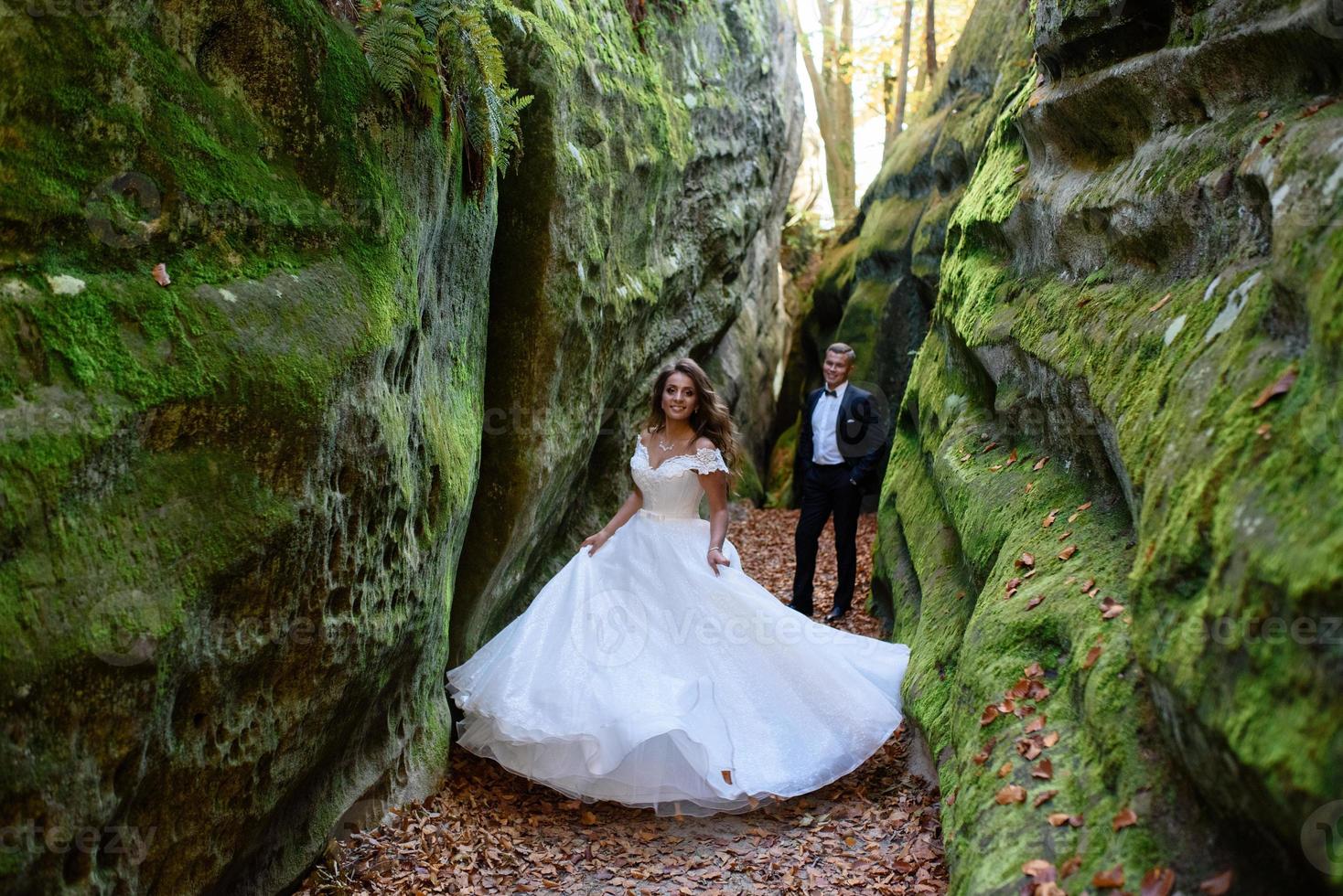 Braut und Bräutigam. ein Paar, das durch die enge, schöne Schlucht schlendert. die Schlucht war mit grünem Moos bewachsen. die Jungvermählten drehen und rennen. foto