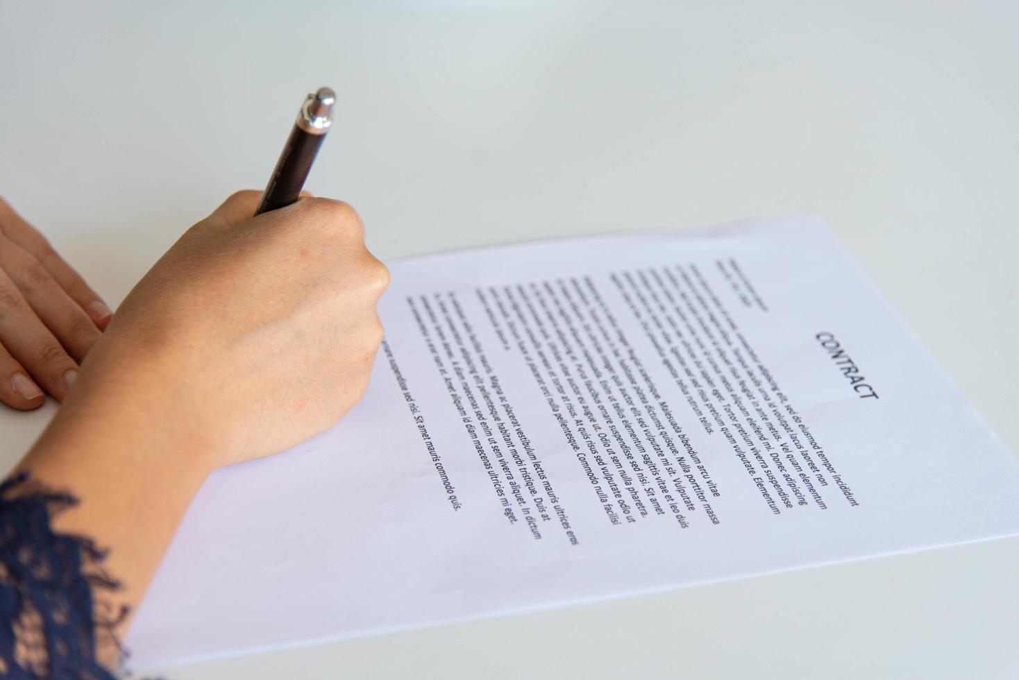 Closeup Frau Handschrift auf weißem Papier Hinweis auf dem weißen Tisch im Büro foto