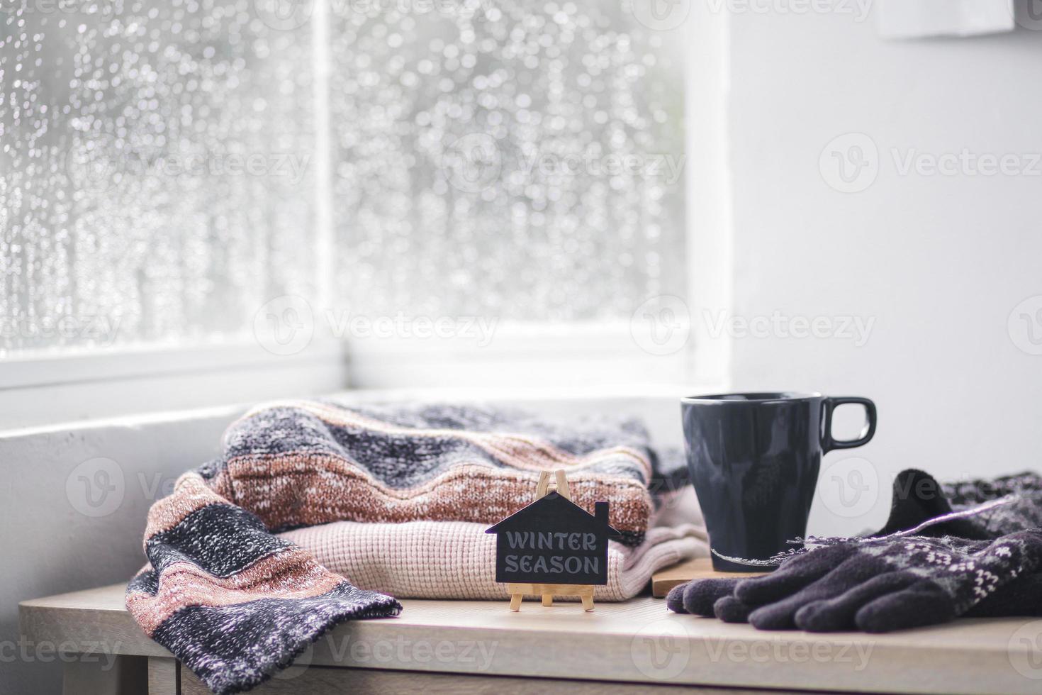 Winterhandschuhe, Mütze und Pullover bei einer Tasse Kaffee zur Begrüßung der Wintersaison foto