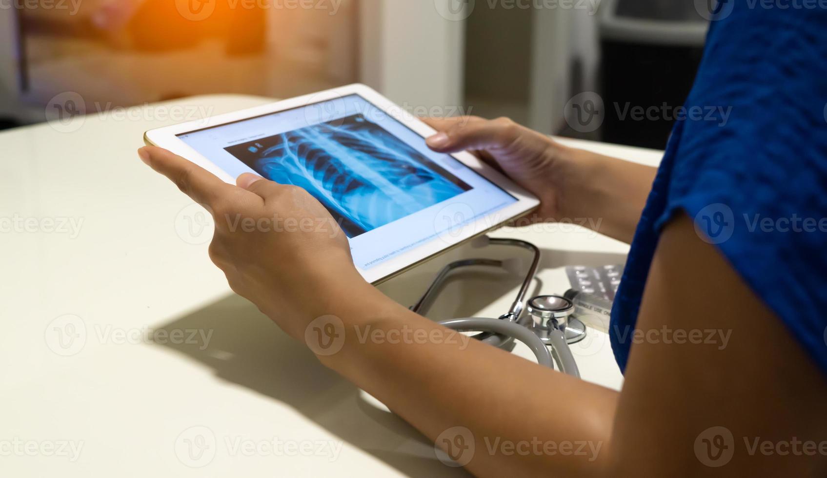 arzt, der das radiologische röntgenbild des brustkorbs auf dem tablet für die medizinische diagnose betrachtet foto