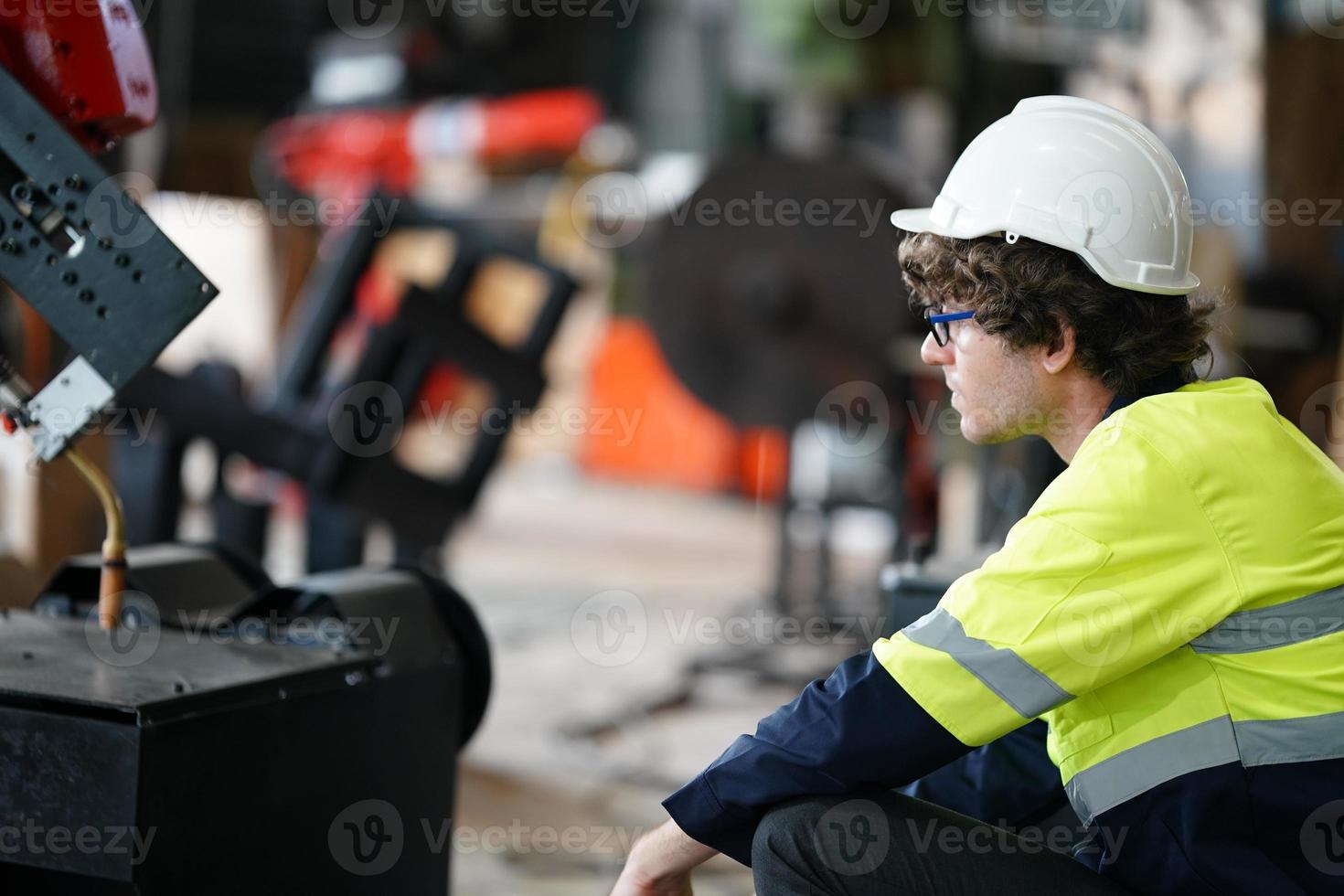 Diverse multikulturelle Ingenieure und Arbeiter der Schwerindustrie in einheitlichen Check-Automatik-Roboterarmen für die Verwendung in der Fabrik. Der männliche Industrieunternehmer verwendet einen Tablet-Computer. foto