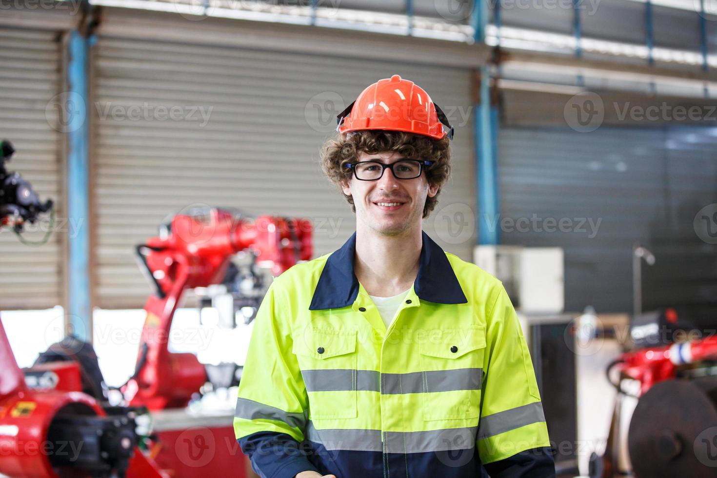 wirtschaftsingenieur oder arbeiter, der einen helm trägt, während er in einer schwerindustriefabrik steht. die Wartung von Arbeiten an Industriemaschinen und die Einrichtung des Sicherheitssystems in der Fabrik. foto