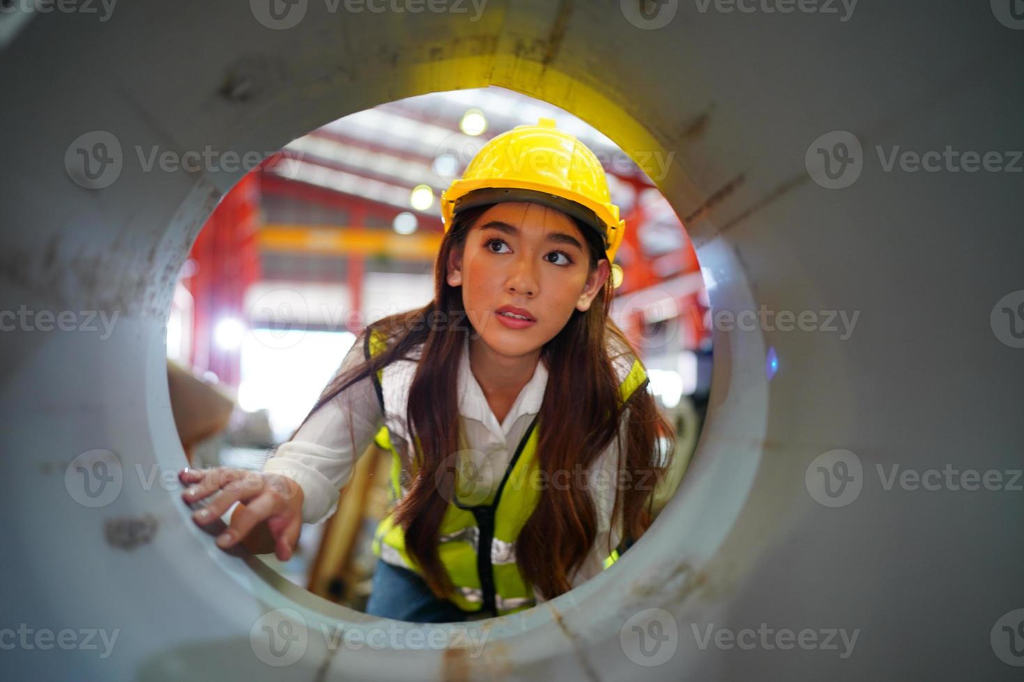 Vorarbeiterin oder Arbeiterin arbeitet auf dem Werksgelände und überprüft Maschinen oder Produkte vor Ort. ingenieur oder techniker, der material oder maschine in der anlage überprüft. Industrie und Fabrik. foto