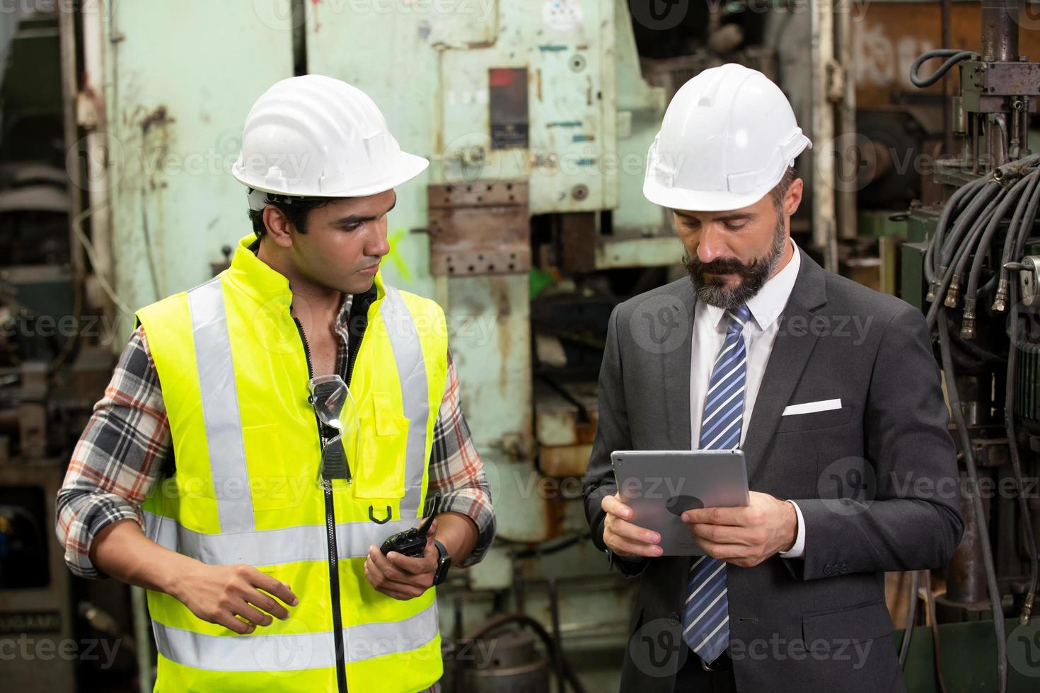 vorarbeiter oder arbeiter arbeiten am fabrikstandort und überprüfen maschine oder produkte vor ort. ingenieur oder techniker, der material oder maschine in der anlage überprüft. Industrie und Fabrik. foto