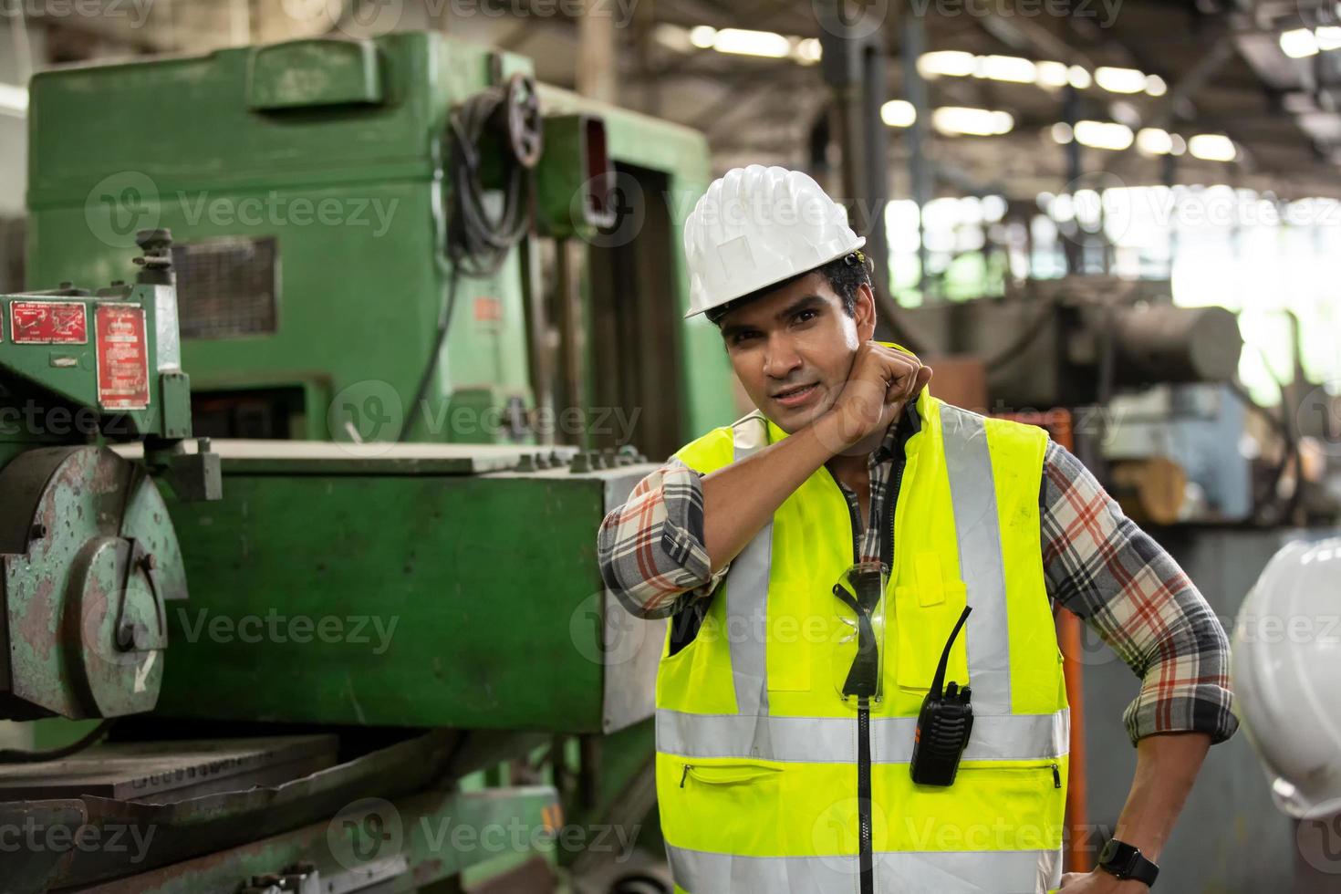 Arbeiter arbeiten auf dem Werksgelände und überprüfen die Maschine in der Produktlinie oder die Produkte vor Ort. ingenieur oder techniker, der material oder maschine in der anlage überprüft. Industrie und Fabrik. foto