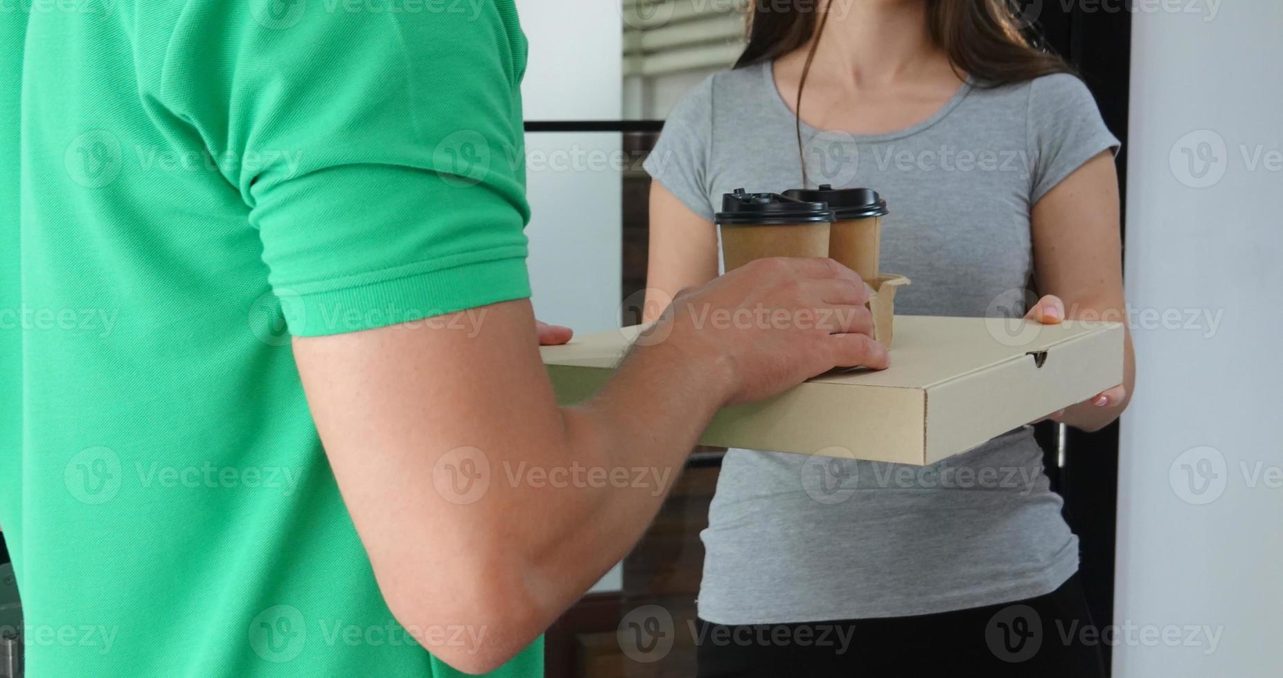 junger mann lieferte das paket. Kurier mit Karton. Paketzustelldienst. foto