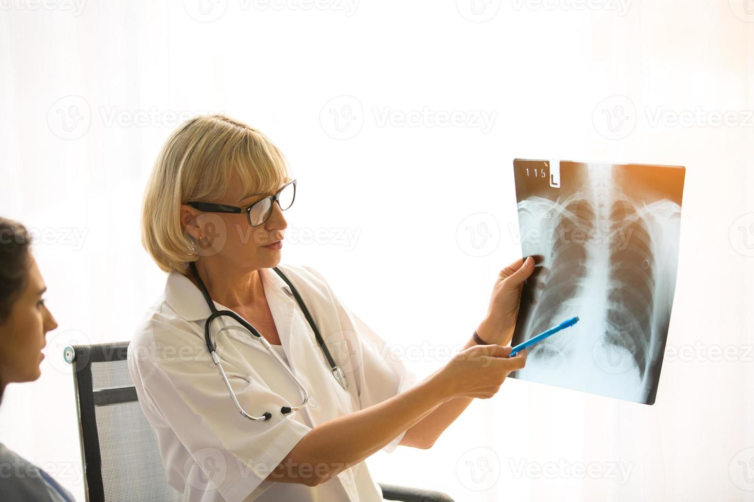ärztin zeigt der patientin ein bild des röntgenfilms und erklärt es ihr. foto