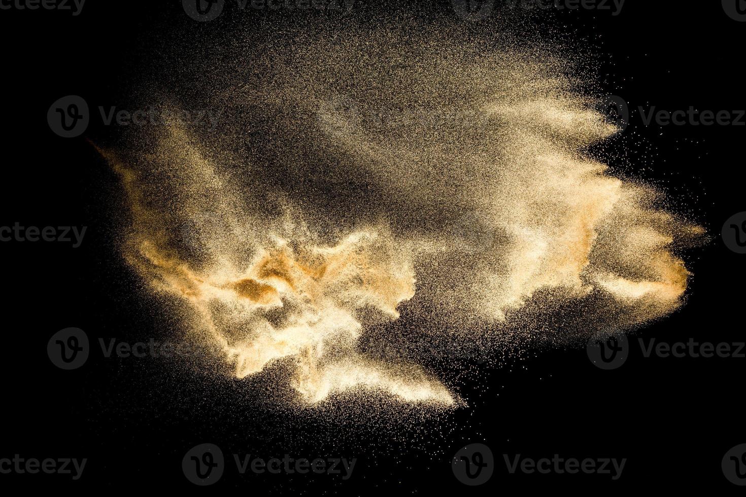 trockene Flusssandexplosion isoliert auf schwarzem Hintergrund. abstrakte Sandwolke. Braun gefärbter Sandspritzer vor dunklem Hintergrund. foto