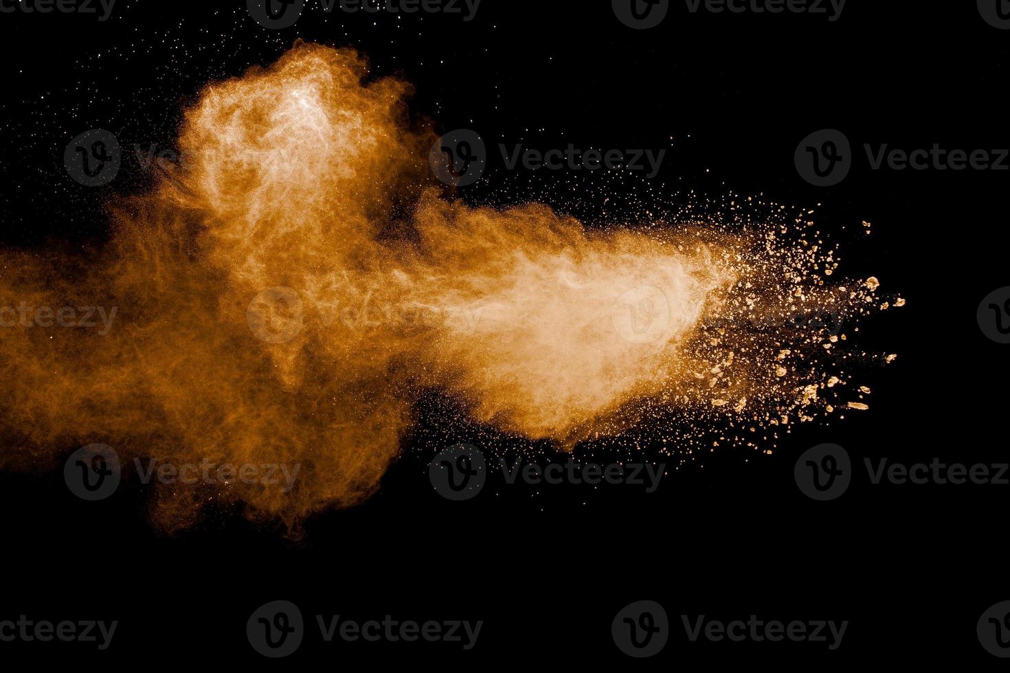 bewegung der braunen staubexplosion einfrieren. die bewegung des braunen pulvers stoppen. explosives braunes pulver auf schwarzem hintergrund. foto