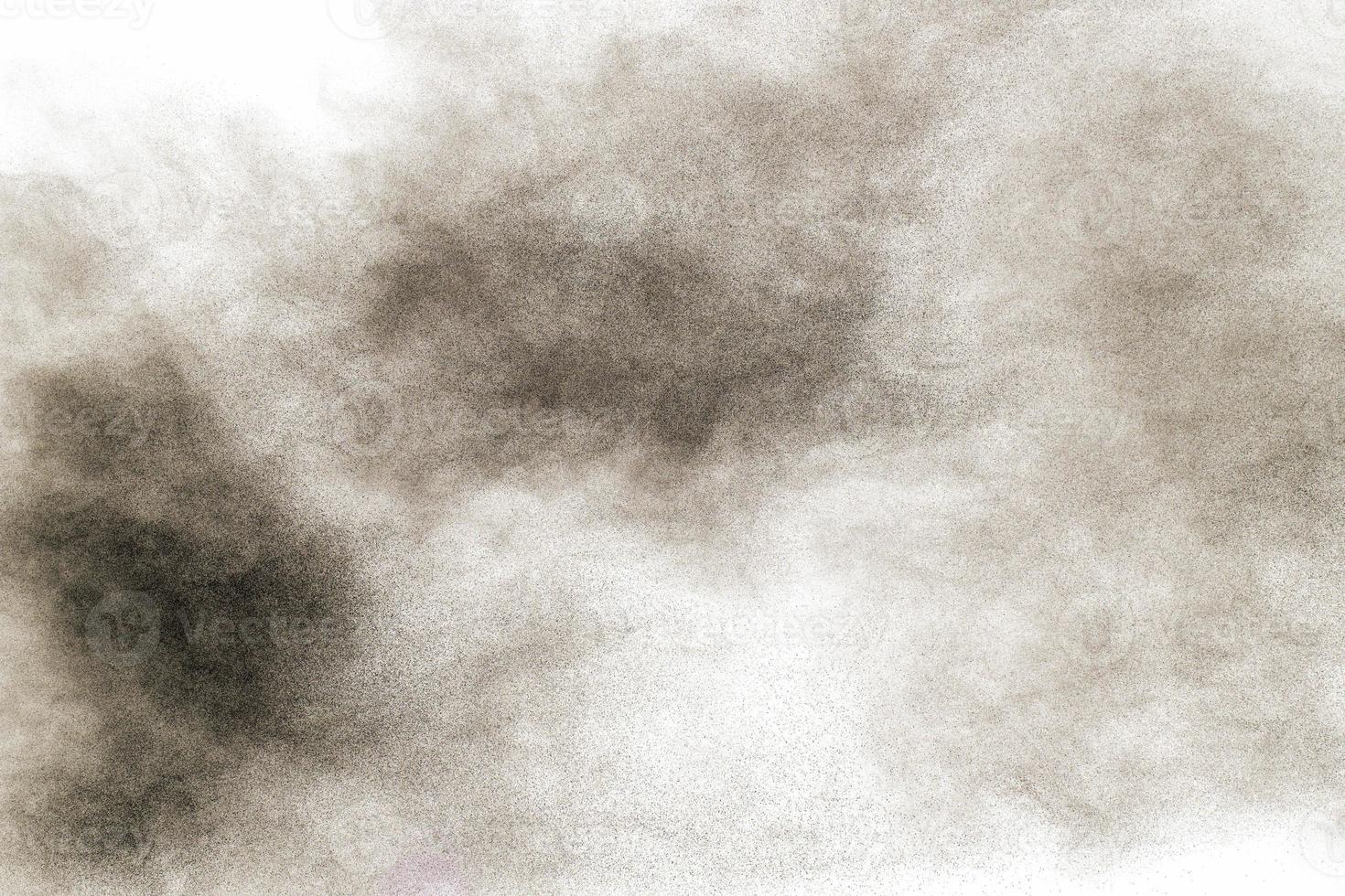 Schwarzpulverexplosion vor weißem Hintergrund. schwarze staubpartikel spritzen. foto