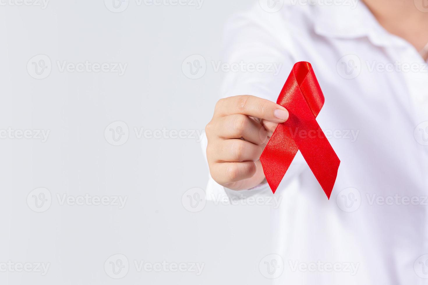 Die Hände des Mädchens halten ein rotes Brustkrebs-Bewusstseinsband und ein Aids-Bewusstseinsband foto