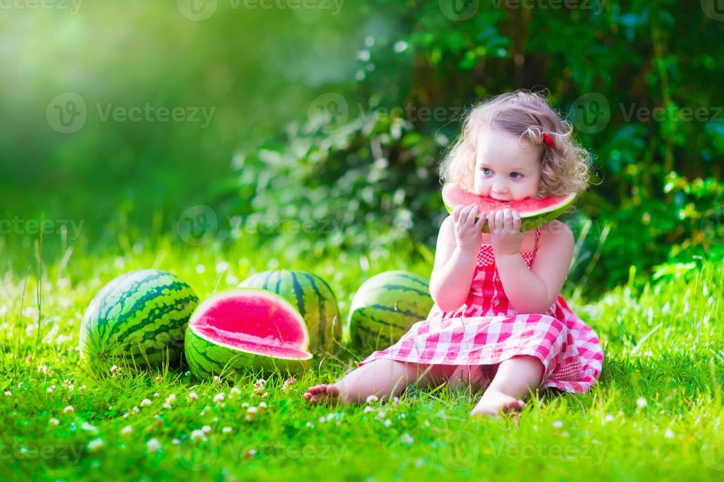 entzückendes kleines Mädchen, das Wassermelone isst foto