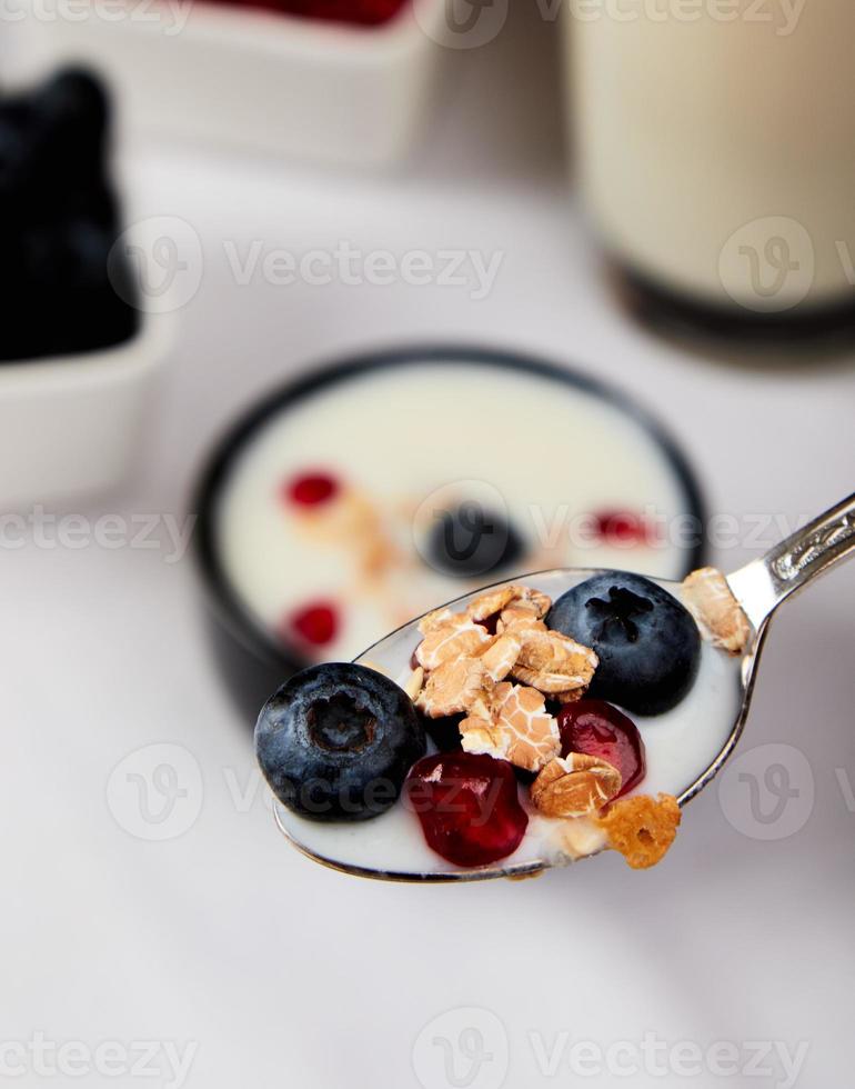 Joghurt mit Müsli, Blaubeeren und Granatapfel foto