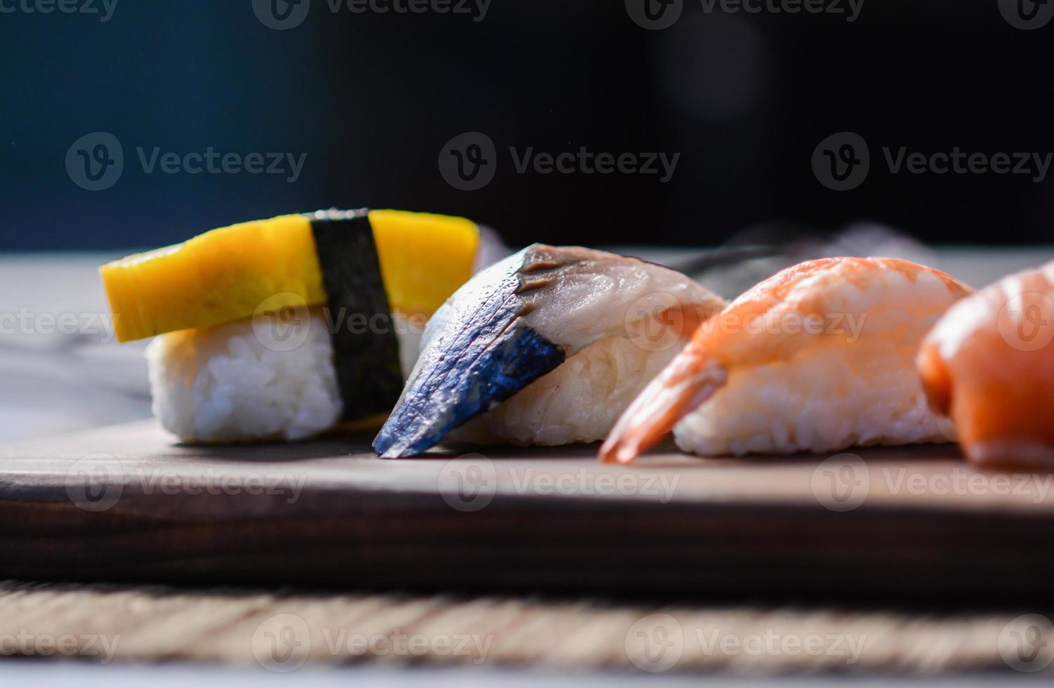 Mischen Sie Sushi auf Holzgericht, Thunfisch, Lachs, Wolfsbarsch, süßes Ei, Garnelen-Sushi, japanisches Essen foto