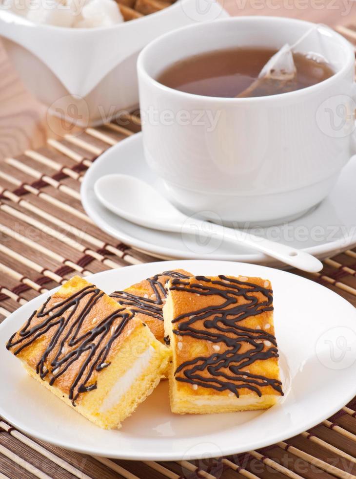 Stück Biskuitkuchen mit Tee und Zucker foto