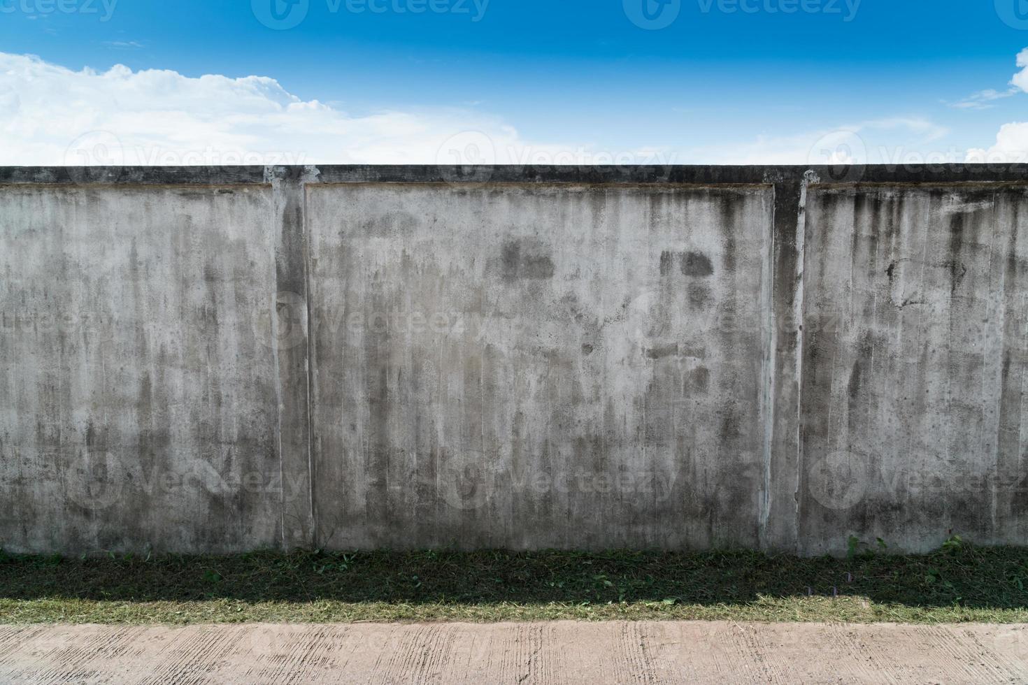 alte rissige graue zement- oder betonwand mit blauem himmel als hintergrund. Grunge verputzter Stuck strukturierter Hintergrund. foto