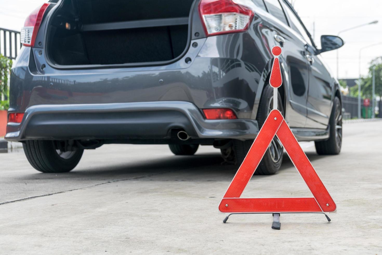 kaputtes Autoschild auf einer Straße mit einem kaputten Auto foto