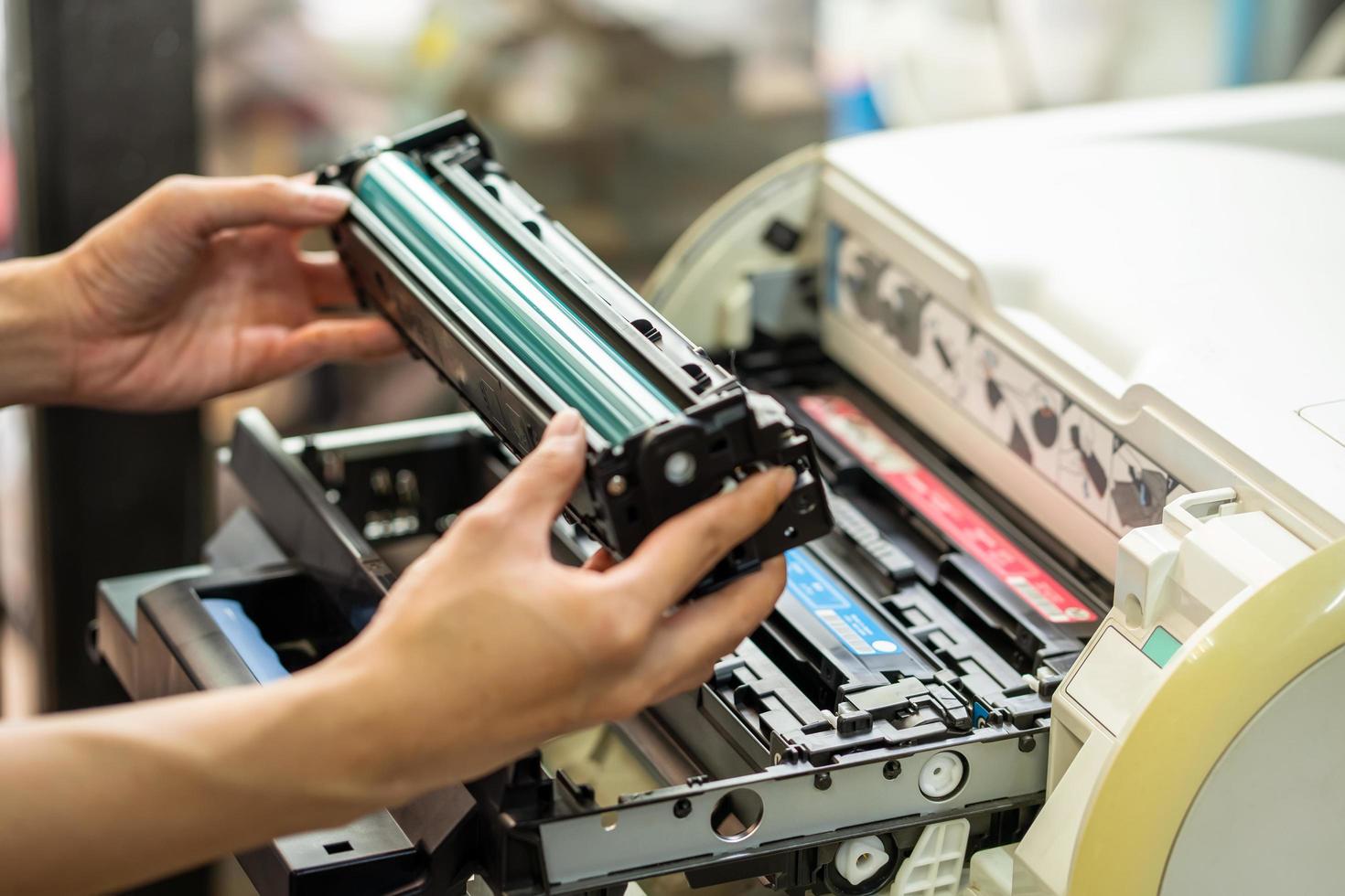 frauen, die eine lasertonerkartusche halten und den toner im laserdrucker im büro ersetzen. reparatur- und wartungsdruckerkonzept, selektiver fokus foto