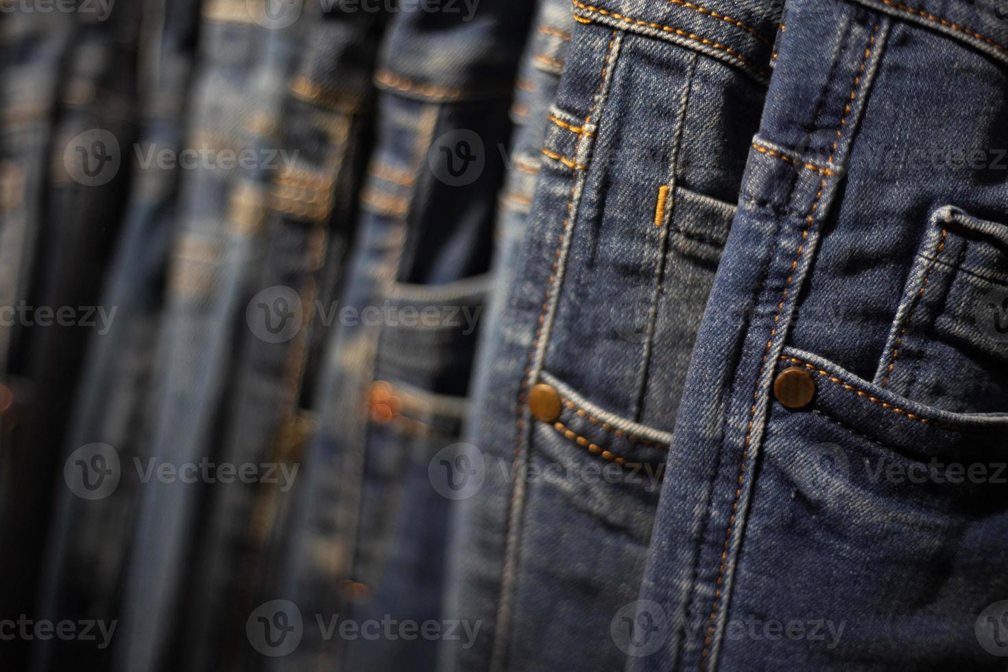 Nahaufnahme Viele Jeans hängen an einem Gestell. Reihe von Hosen Jeans im Schrank hängen. foto