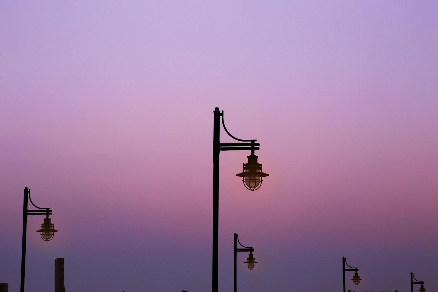 Reihe von Laternen zur violetten Sonnenuntergangszeit foto