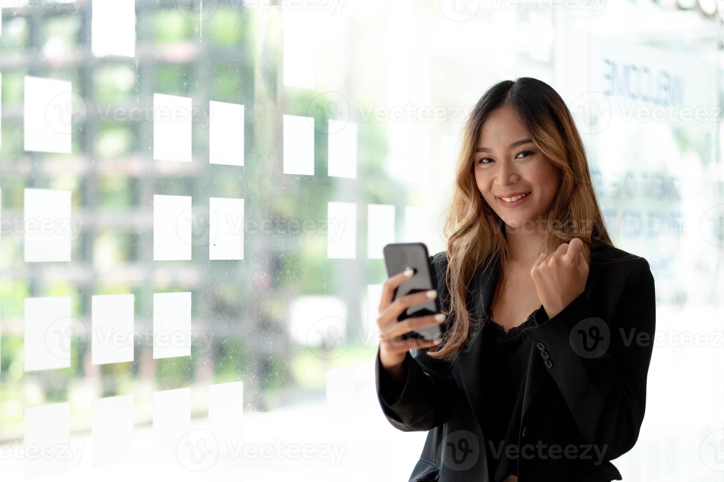 schöne asiatische frau, die smartphone verwendet, aufregend und feiert mit guten nachrichten des geschäfts erfolgreich. Startup-Konzept für kleine Unternehmen. foto