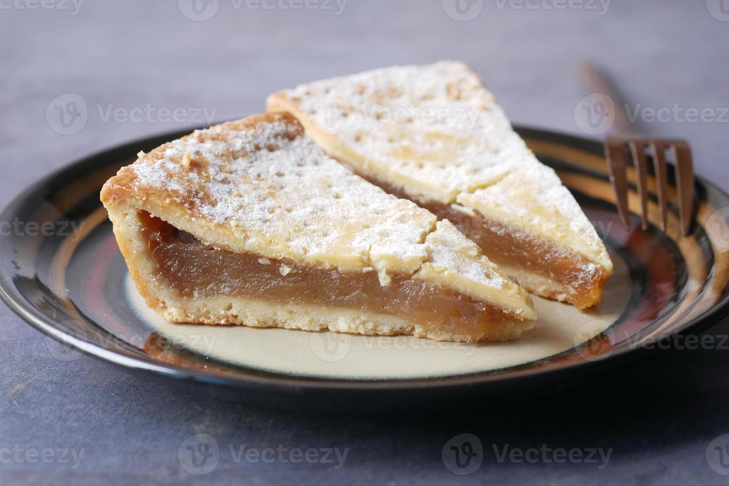 Stück Apfelkuchen auf einem Teller auf schwarzem Hintergrund foto