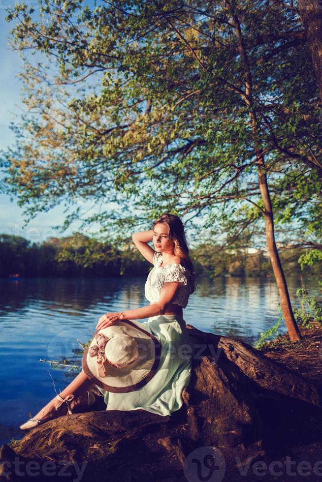 Frau mit Hut am Fluss foto