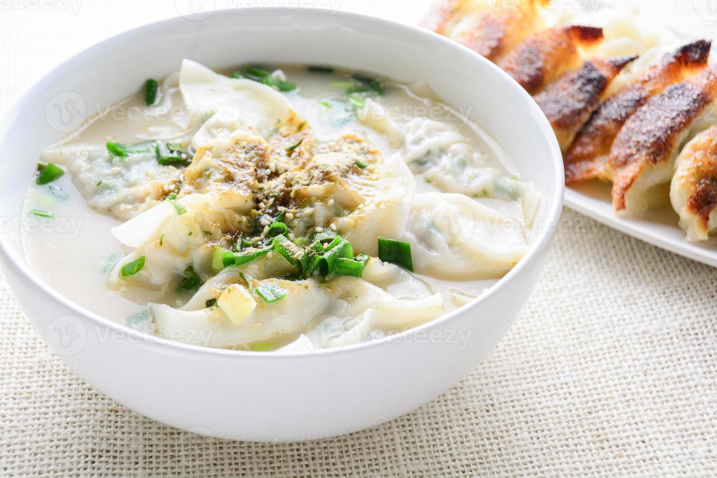 Wan-Tan-Suppe mit Frühlingszwiebeln, serviert in einer weißen Schüssel, selektiver Fokus foto