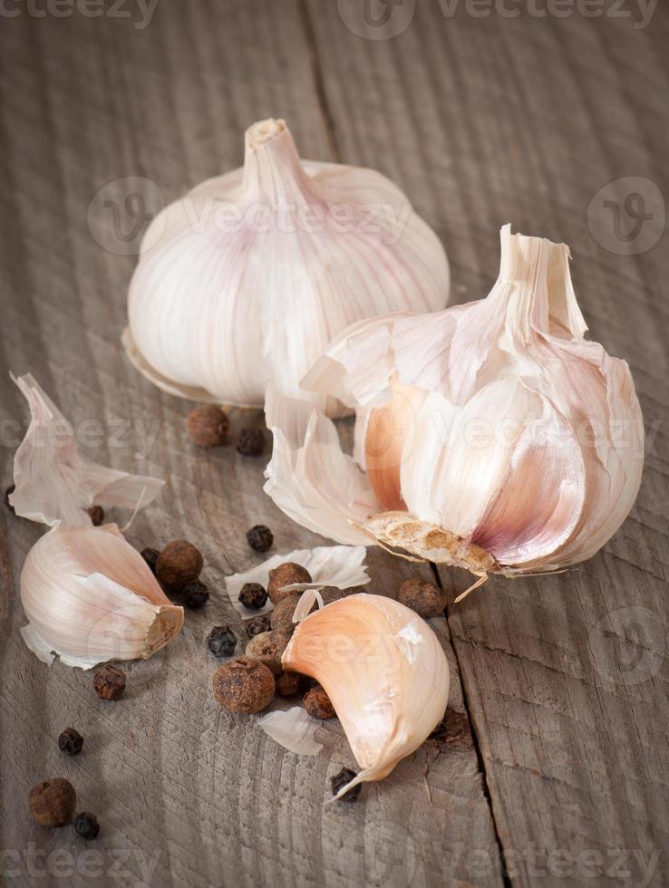 Knoblauch und Pfeffer auf einem hölzernen Hintergrund foto