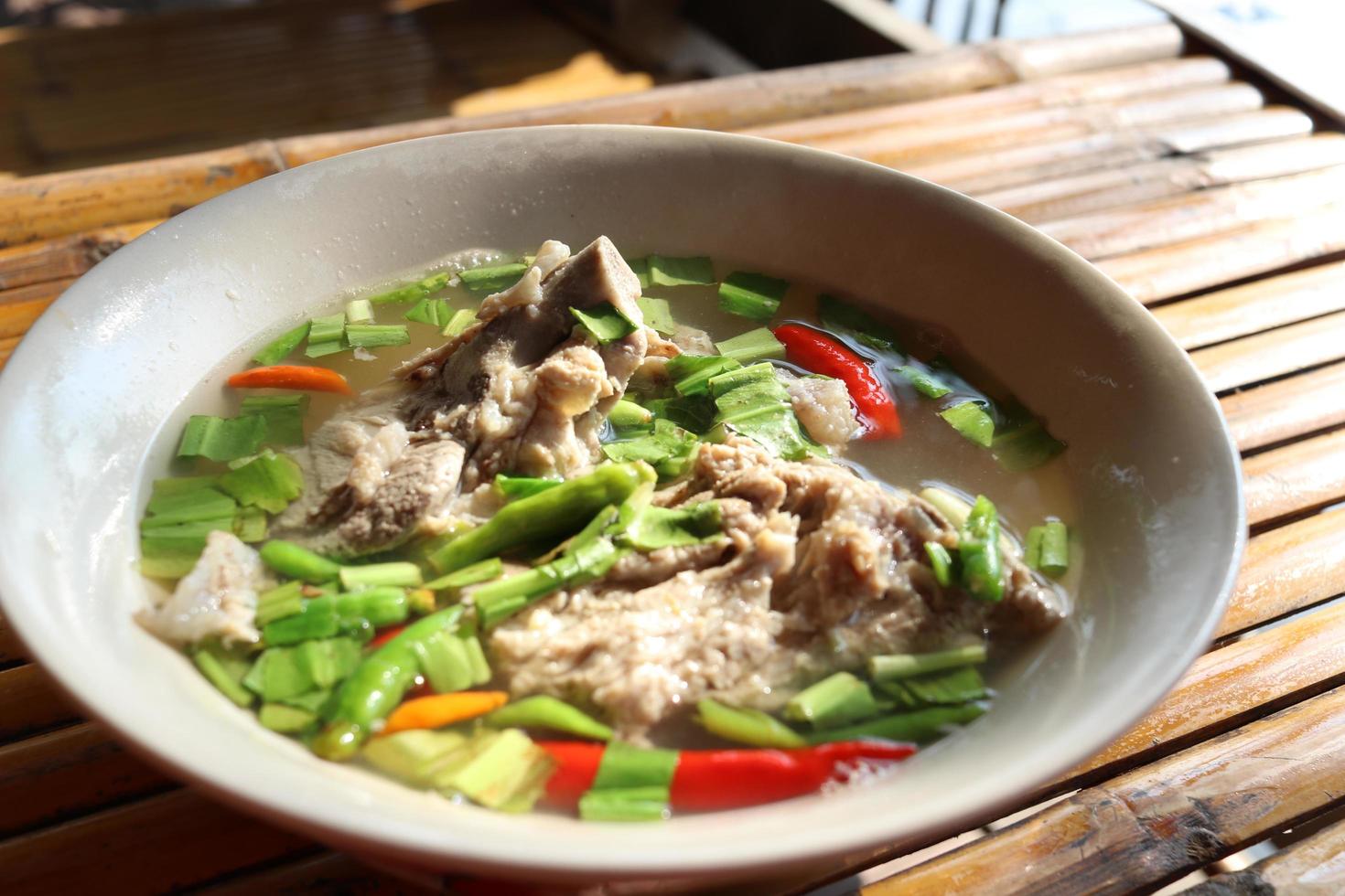 scharfe und würzige suppe mit schweinerippchen in schüssel, thailand. foto