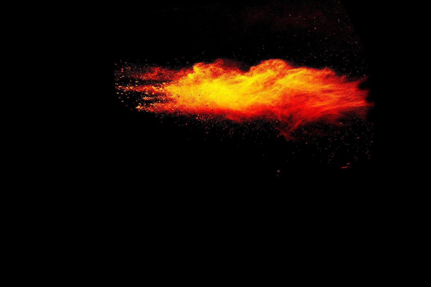 Explosionswolke des roten orange Farbpulvers lokalisiert auf schwarzem Hintergrund. foto