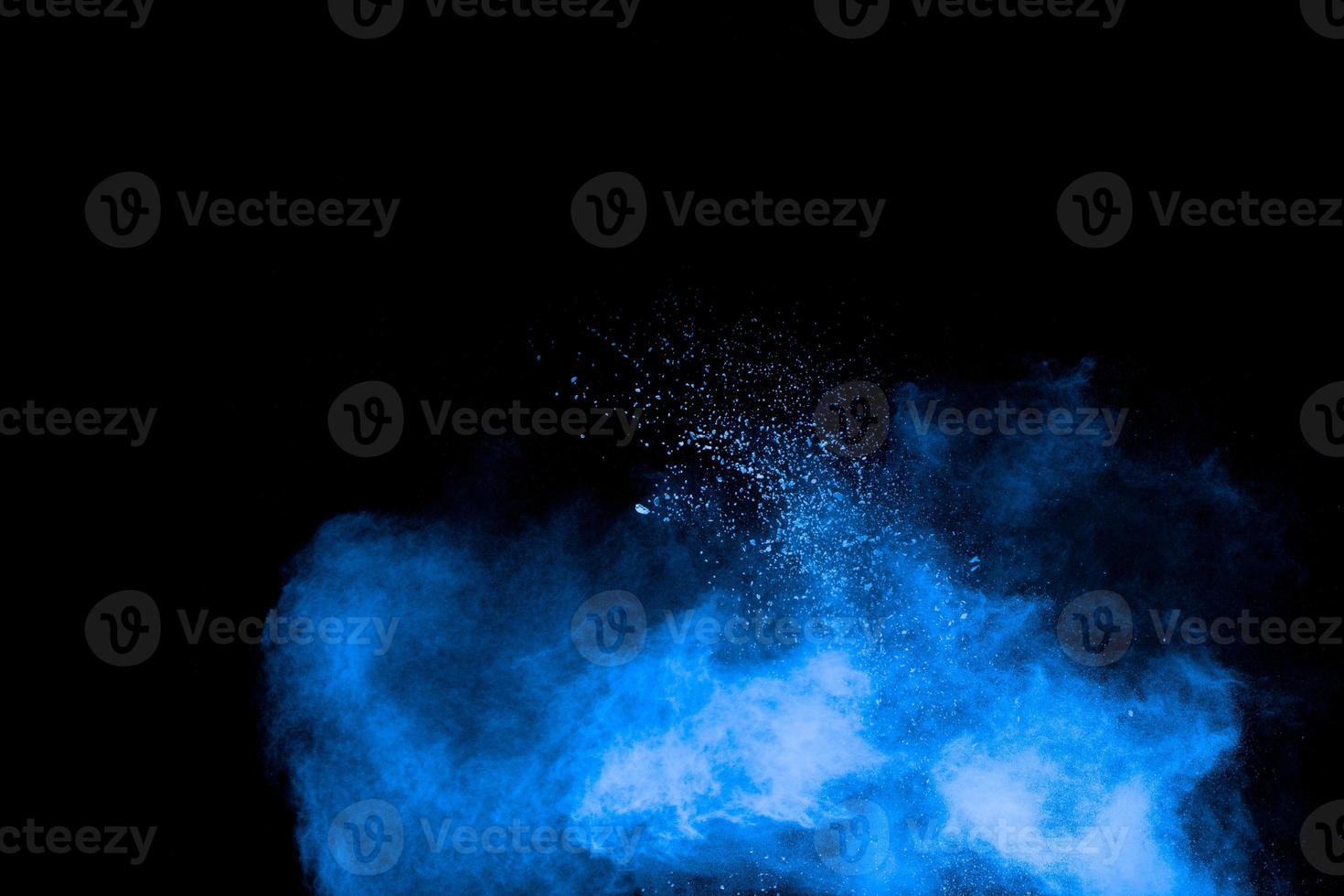 blaue pulverexplosionswolke auf schwarzem hintergrund. gestartete blaue staubpartikel spritzen auf hintergrund. foto
