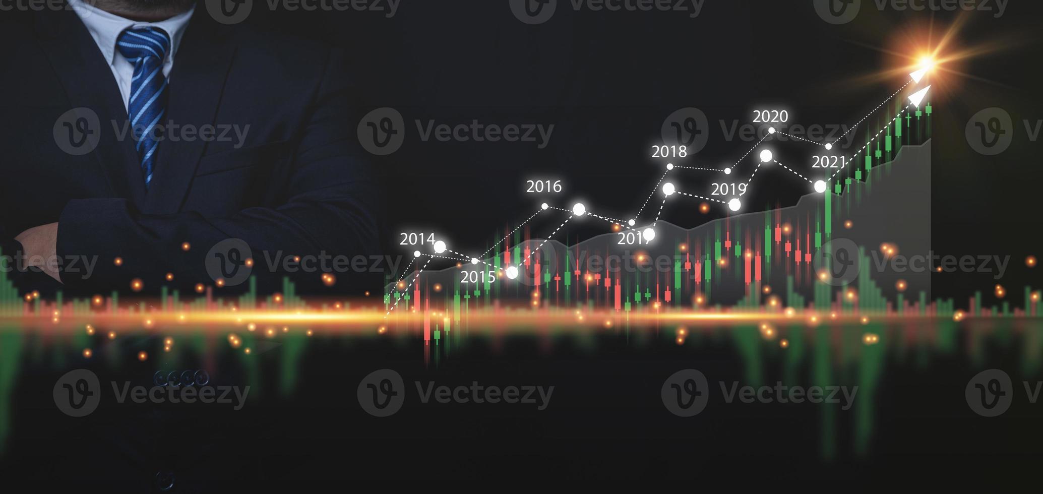 Geschäftswachstumsdiagramme, Finanzen, Aktienhandel, Investitionsanalyse und Aktienmarktanalyse. Geschäftsmann, der einen Anzug mit verschränkten Armen trägt, mit Marktanalysen für Geschäftswachstumsdiagramme. foto