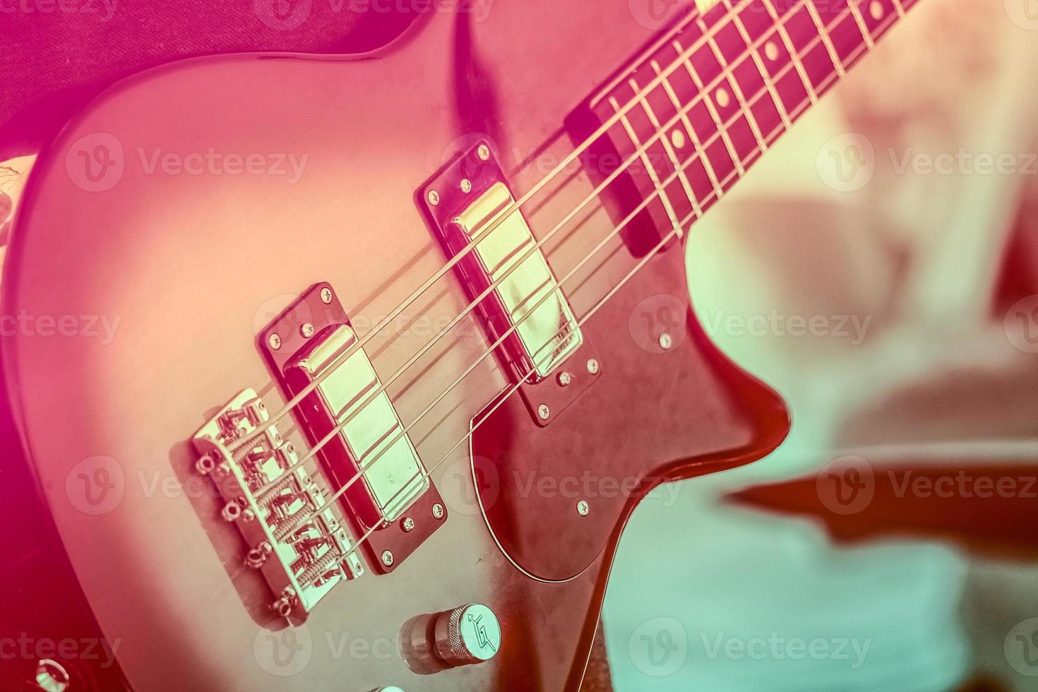 Musikinstrument Gitarre Bass auf einem violetten Duo-Ton-Vintage-Stil foto