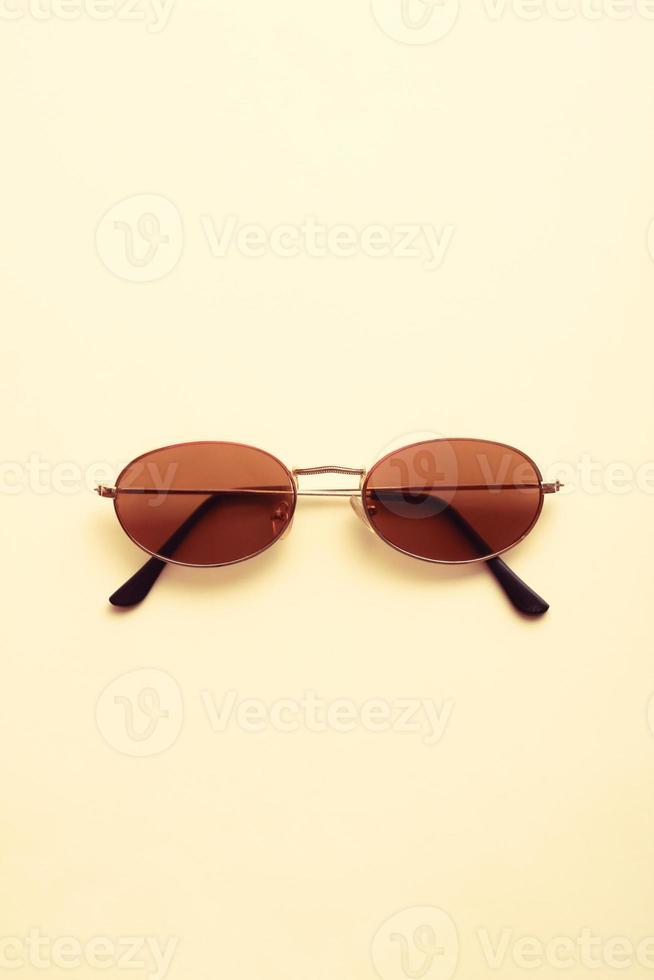 braune Sonnenbrille auf hellem cremeweißem Hintergrund. foto