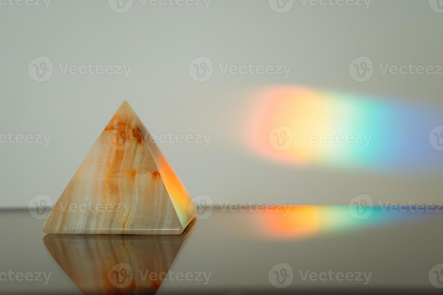 Achatpyramide mit einem Regenbogenstreifenhintergrund foto