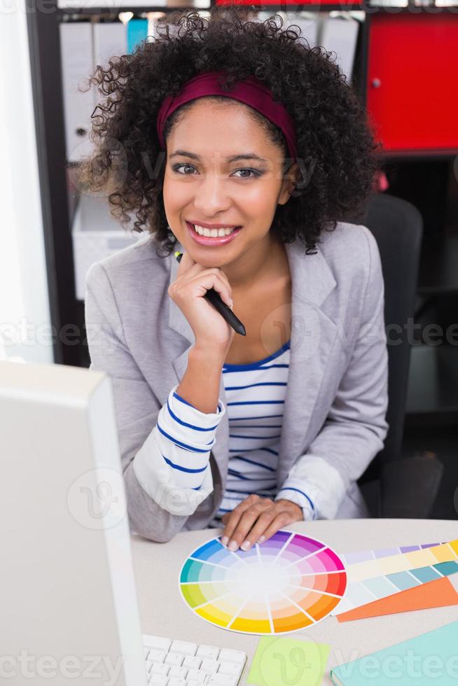 lächelnder weiblicher Bildbearbeiter am Schreibtisch foto