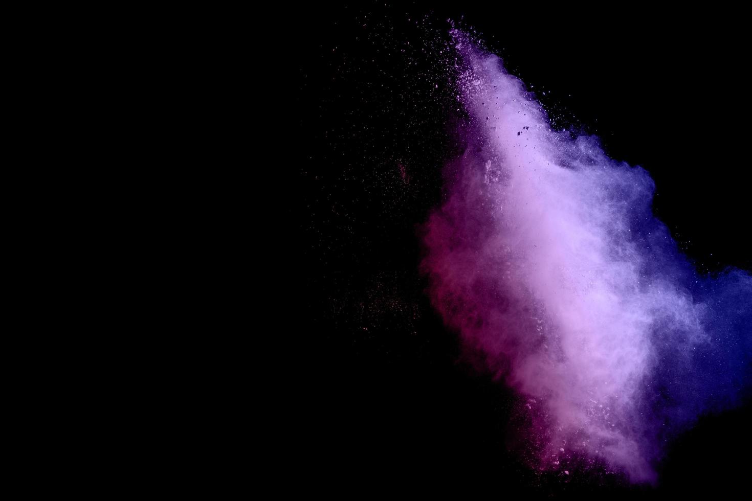 Bewegungsexplosion von violettem Pulverstaub auf schwarzem Hintergrund einfrieren. foto