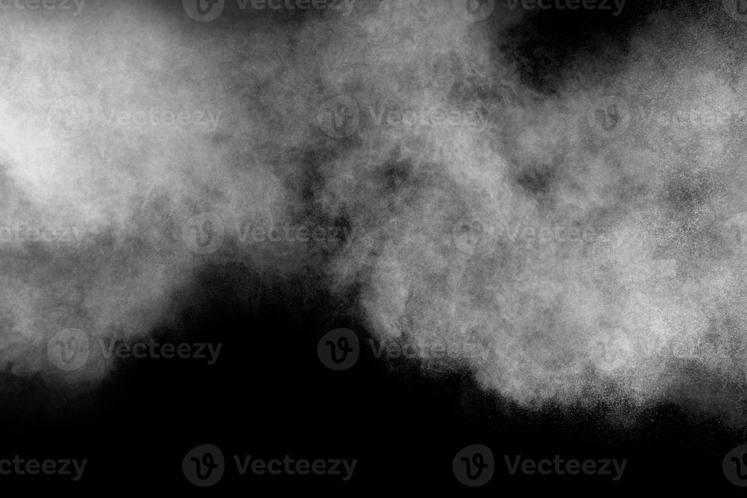 bizarre formen der explosionswolke des weißen pulvers gegen schwarzen hintergrund. foto