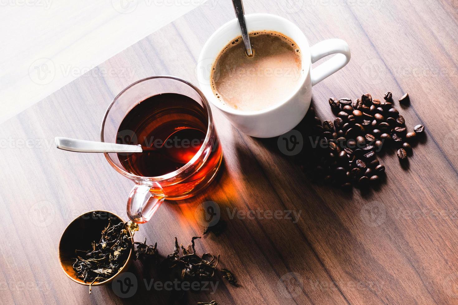 kaffee und tee mit kaffeebohne und teeblättern auf holzboden. foto