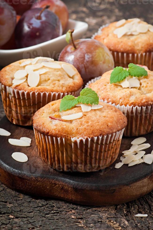 Muffins mit Pflaumen und Mandelblättern, verziert mit Minzblättern foto