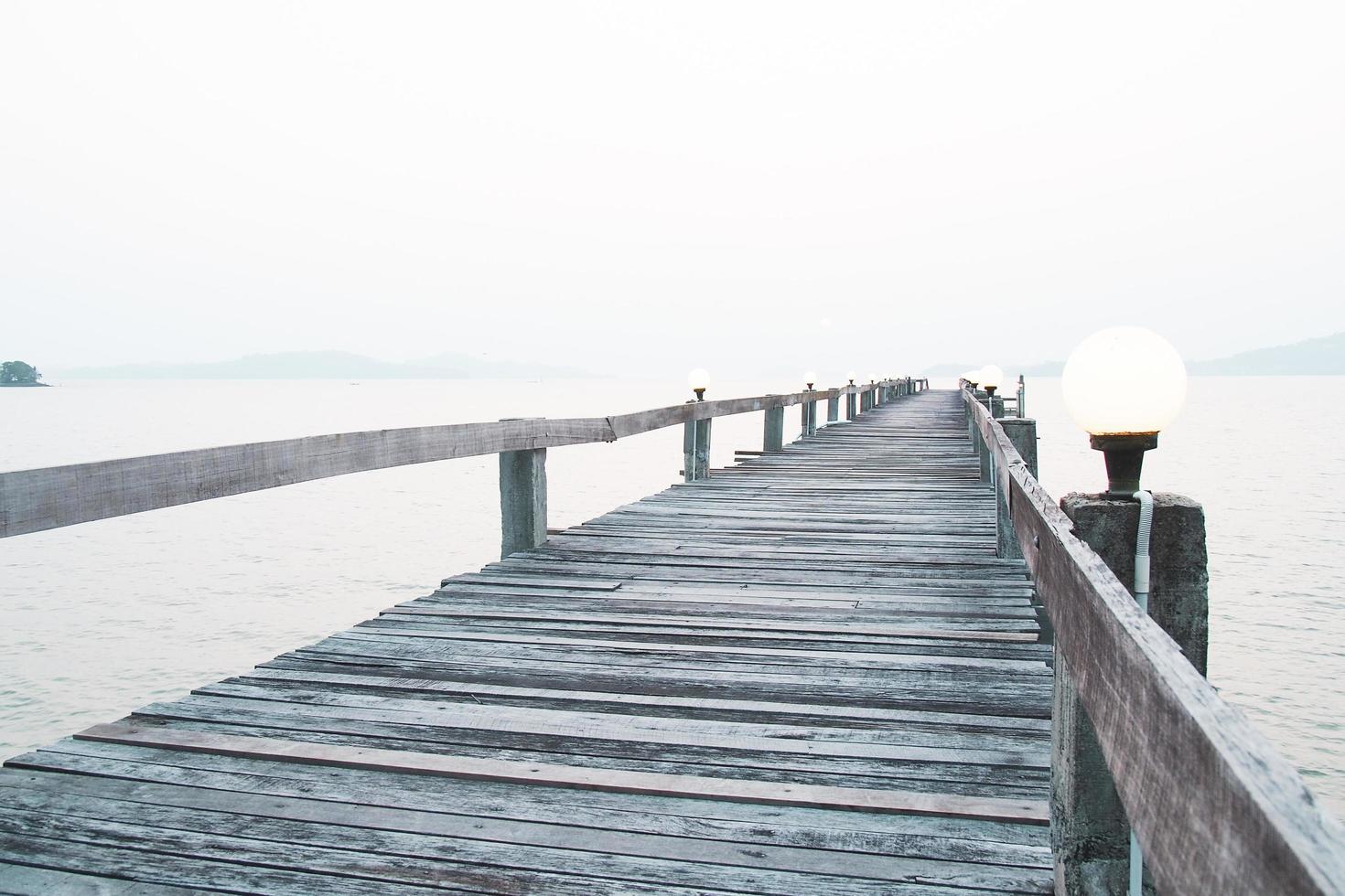 ein Holzsteg, der sich ins Meer erstreckt. Urlaubsreisekonzept foto